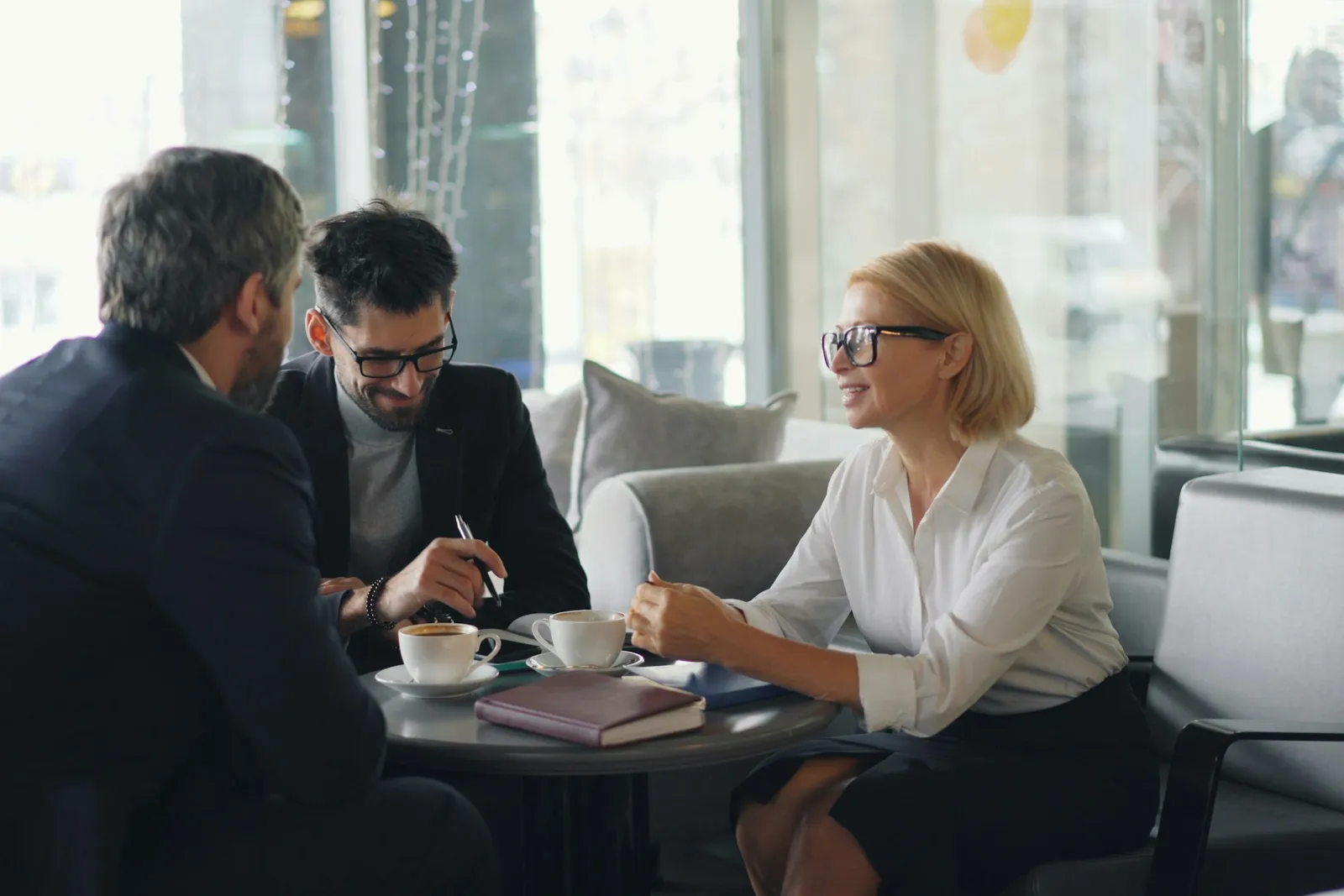 Un couple et sa conseillère autour d'une table, dossier de financement ouvert