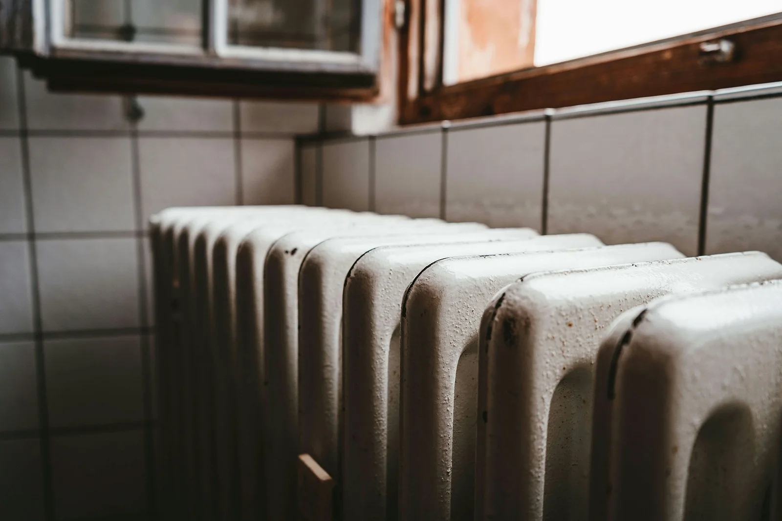 Radiateur en fonte sous une fenêtre à croisillons